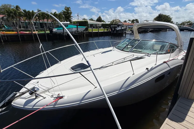 Slide: The Image of 2012 Sea Ray Sundancer 350 docked in a sunny marina, showcasing sleek design and luxury. - 4