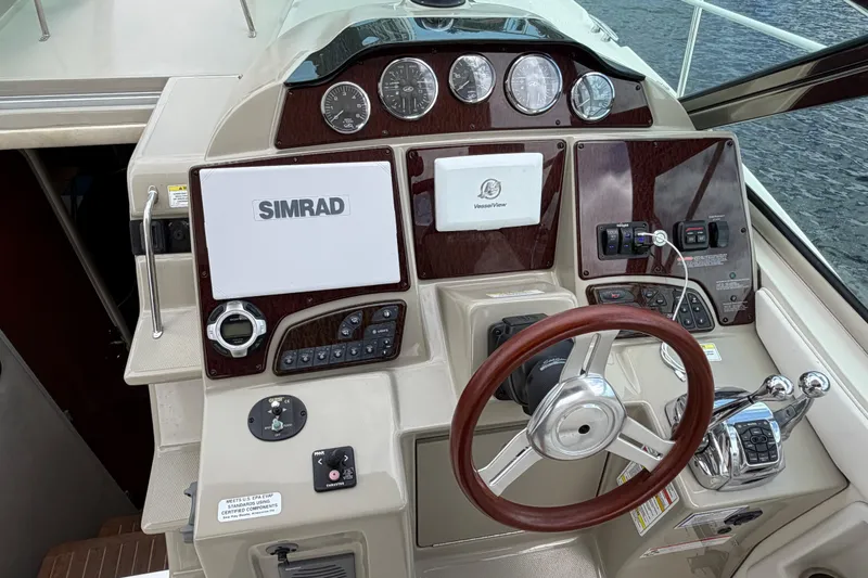 Slide: The Image of Cockpit of 2012 Sea Ray Sundancer 350 with Simrad navigation system and wooden steering wheel. - 54
