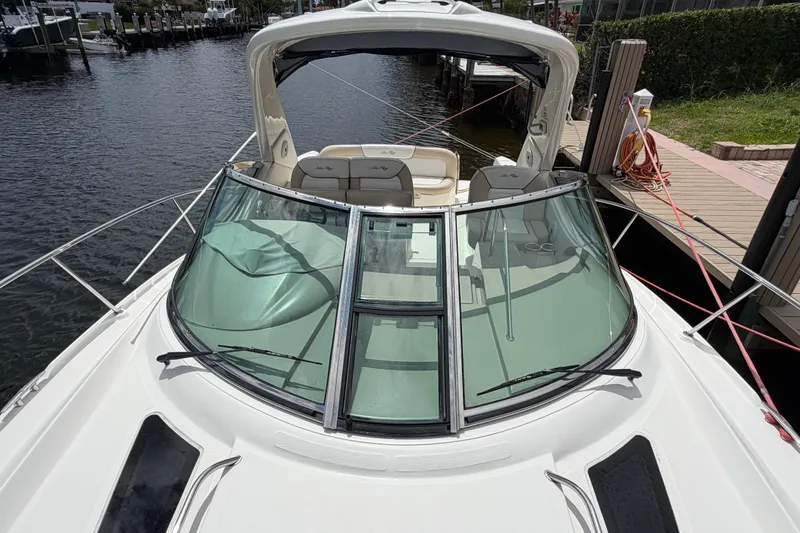 Slide: The Image of 2012 Sea Ray Sundancer 350 docked, showcasing sleek design and spacious seating area. - 62