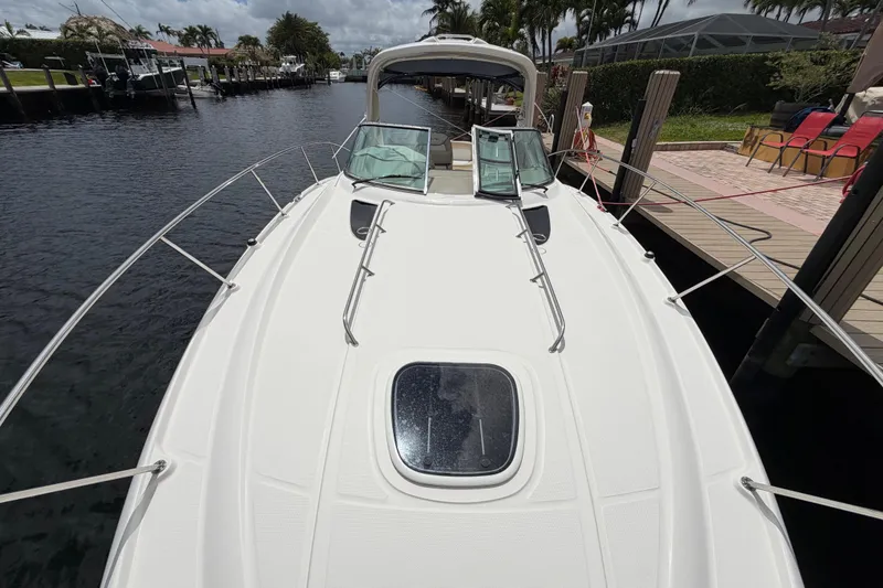 Slide: The Image of 2012 Sea Ray Sundancer 350 docked, showcasing sleek deck design and waterfront setting. - 63