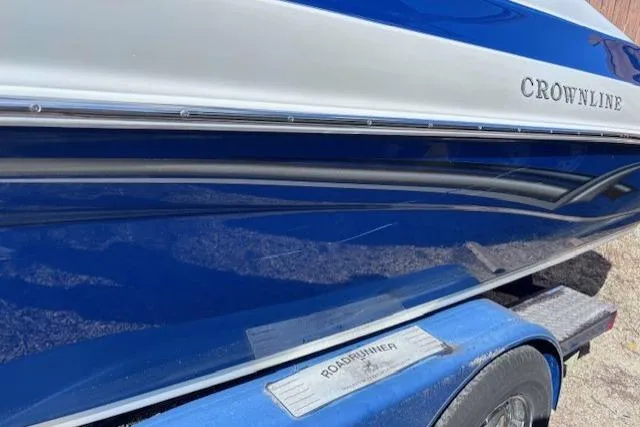 Slide: The Image of 2005 Crownline 202 BR boat with blue and white exterior on a trailer. - 4