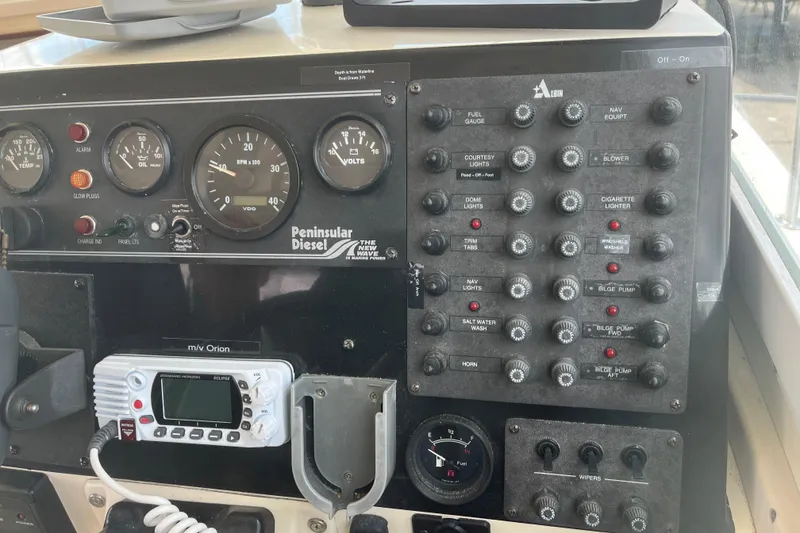 Slide: The Image of Control panel of a 1998 Albin 28 Tournament Express boat with gauges and switches. - 12