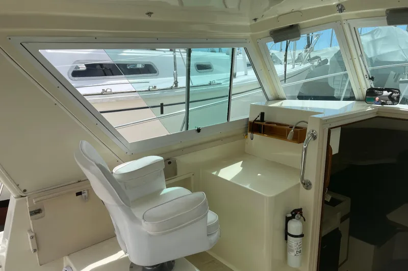 Slide: The Image of Interior of a 1998 Albin 28 Tournament Express boat with helm seat and windows. - 16