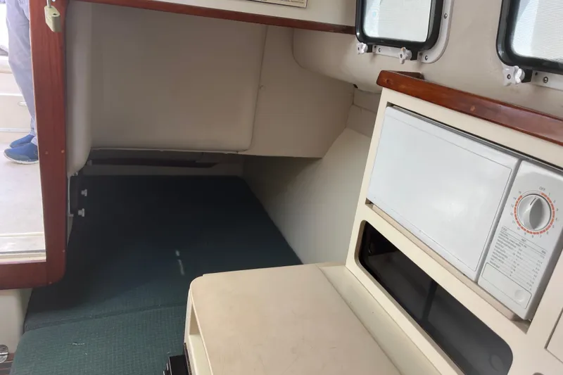 Slide: The Image of Interior cabin of 1998 Albin 28 Tournament Express with microwave and seating area. - 19