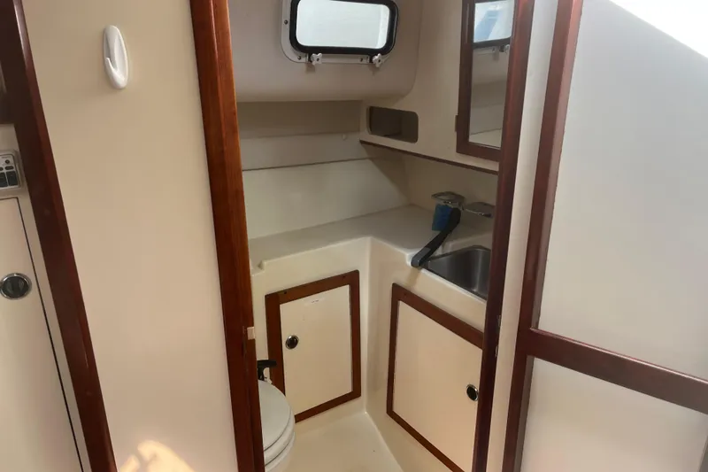Slide: The Image of 1998 Albin 28 Tournament Express boat interior with sink, toilet, and storage cabinets. - 21