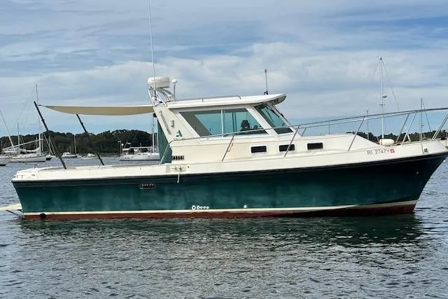 Slide: The Image of 1998 Albin 28 Tournament Express boat on calm water, featuring a green hull and white cabin. - 3