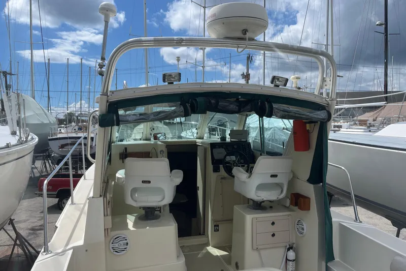 Slide: The Image of 1998 Albin 28 Tournament Express boat interior with helm and seating, docked at marina. - 7