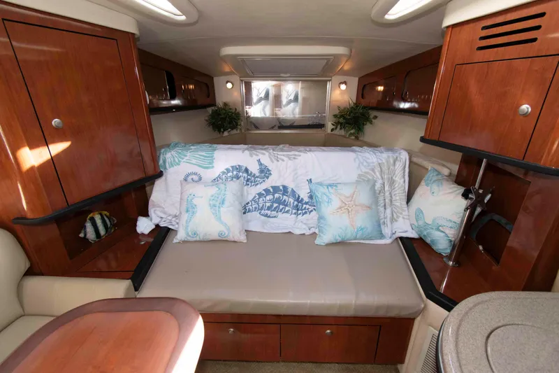 Slide: The Image of Interior of 2007 Sea Ray 290 Sundancer with cozy seating and nautical-themed decor. - 12