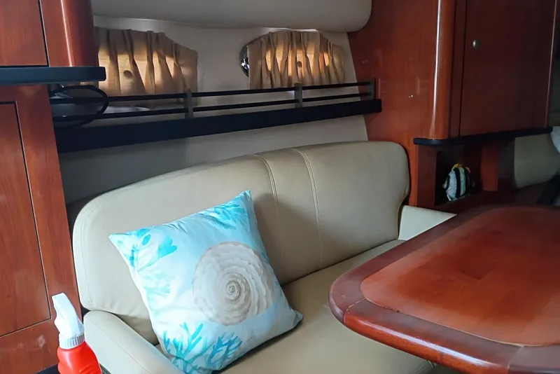 Slide: The Image of Interior of 2007 Sea Ray 290 Sundancer with white seating and wood-style flooring. - 2