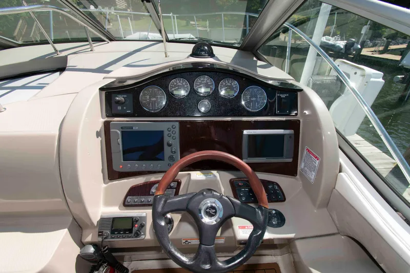 Slide: The Image of 2007 Sea Ray 290 Sundancer helm with gauges, steering wheel, and navigation equipment. - 7