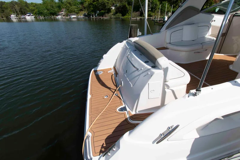 Slide: The Image of 2007 Sea Ray 290 Sundancer boat with spacious deck and seating, docked on calm water. - 8