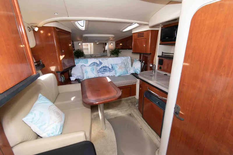 Slide: The Image of Interior of 2007 Sea Ray 290 Sundancer boat with wood finishes and cozy seating area. - 9