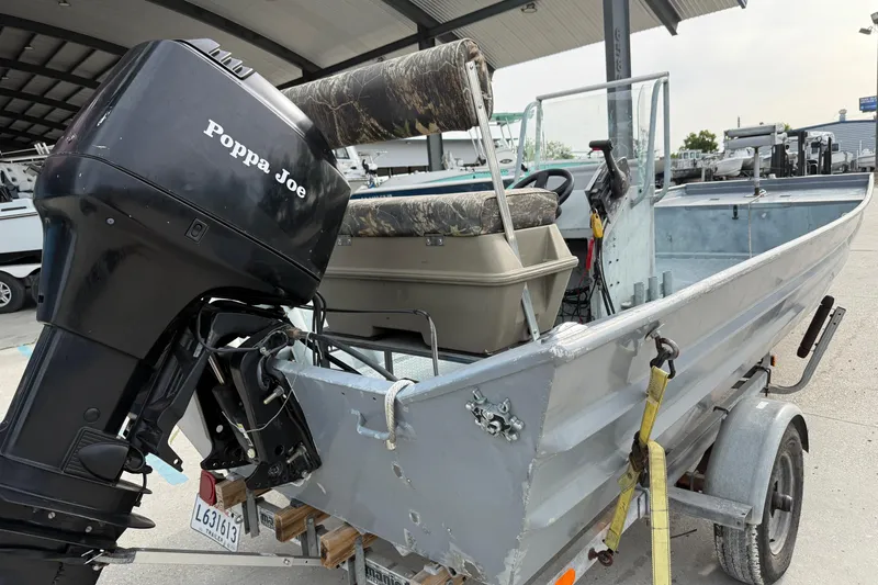 Slide: The Image of 2004 Tims Flat Boat 18x60 with motor named "Poppa Joe" on a trailer. - 10