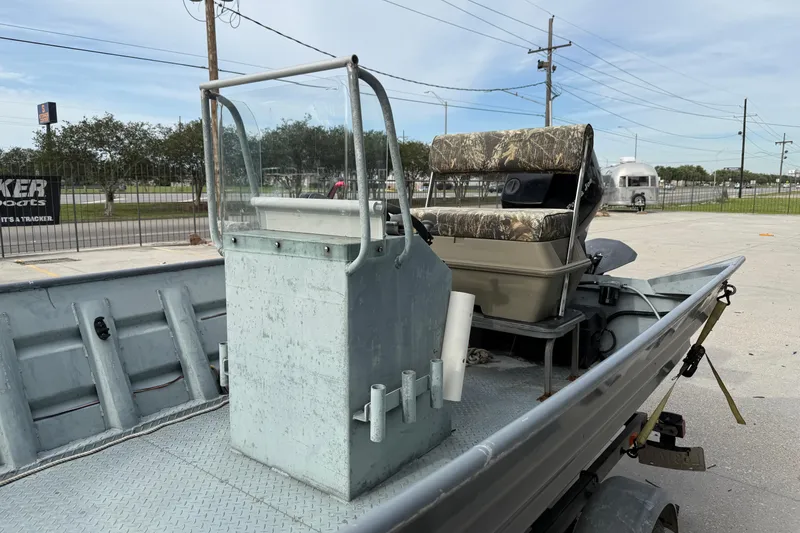 Slide: The Image of 2004 Tims Flat Boat 18x60 with console and camo seating, parked outdoors. - 6