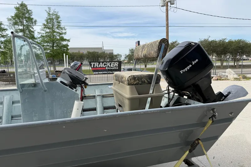 Slide: The Image of 2004 Tims Flat Boat 18x60 with Poppa Joe motor, parked outdoors. - 7