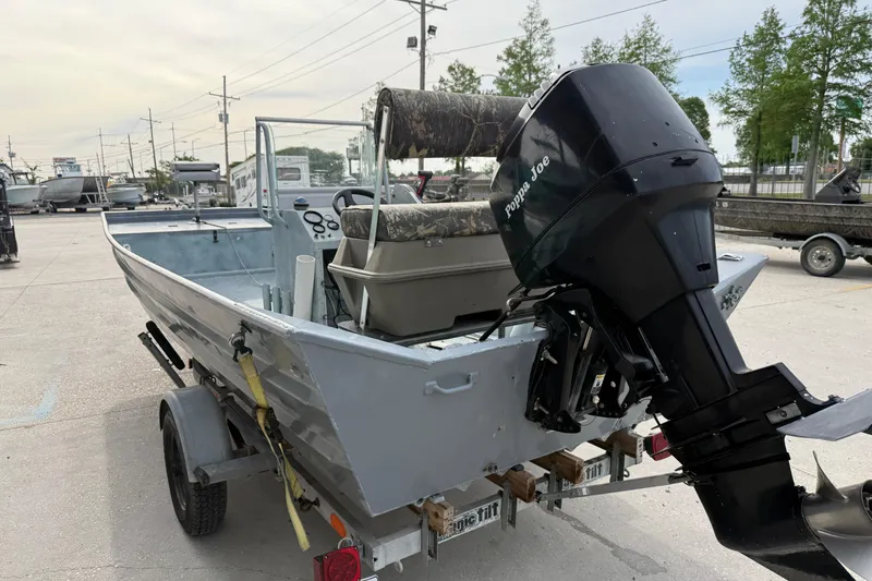 Slide: The Image of 2004 Tims Flat Boat 18x60 with outboard motor on trailer in parking lot. - 9