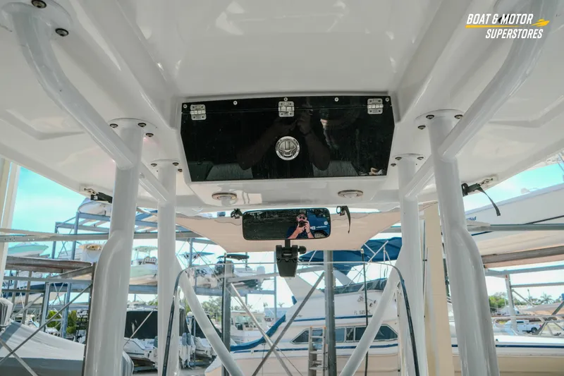 Slide: The Image of 2022 Blackfin 222 CC boat interior with overhead storage and marina background. - 17