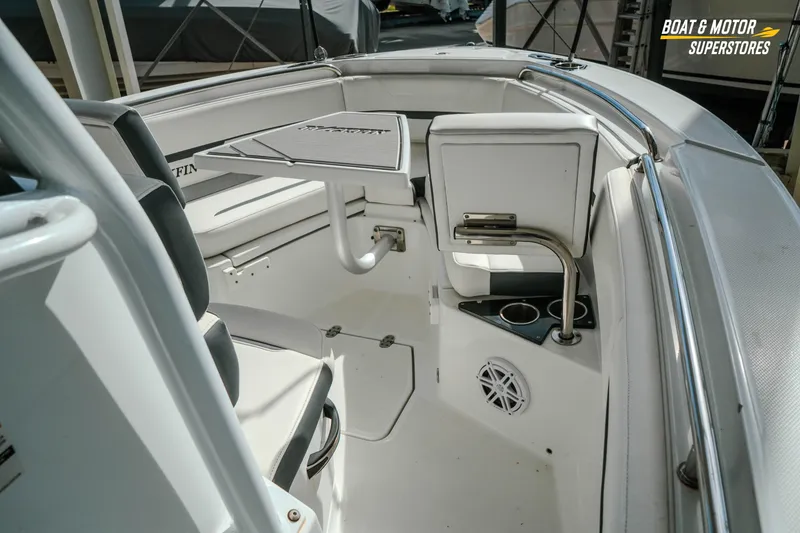 Slide: The Image of 2022 Blackfin 222 CC boat interior with seating, table, and cup holders. - 25