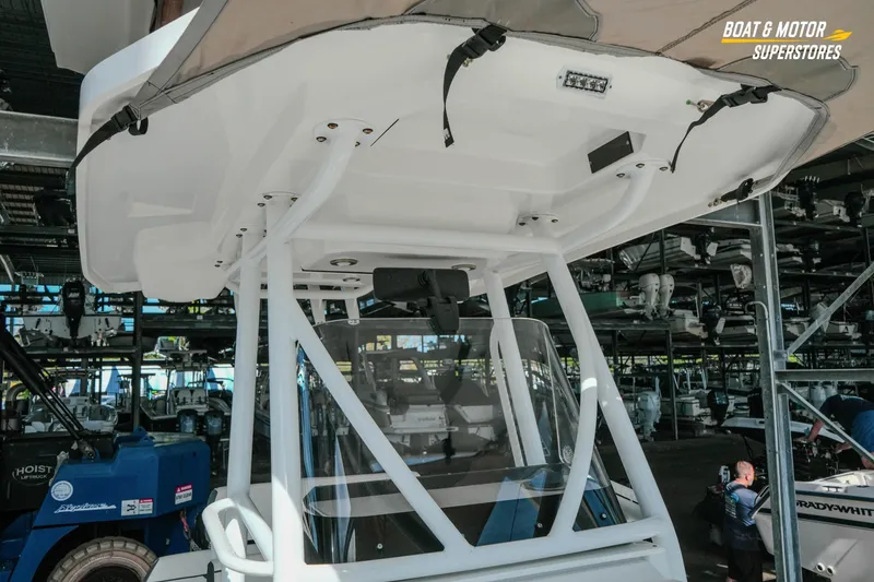 Slide: The Image of 2022 Blackfin 222 CC boat in storage facility, showcasing T-top and console. - 30