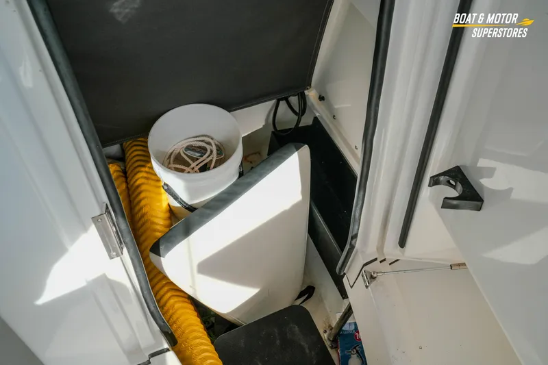 Slide: The Image of Interior storage of 2022 Blackfin 222 CC boat with bucket and yellow hose. - 34