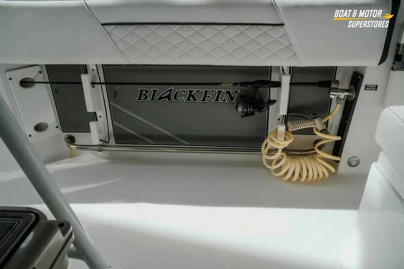 Slide: The Image of 2022 Blackfin 222 CC boat interior with fishing rod holder and fresh water hose. - 46