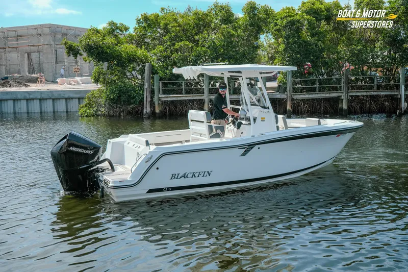 Slide: The Image of 2022 Blackfin 222 CC boat on water near dock, featuring Mercury engine. - 54