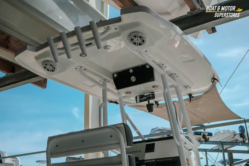 Slide: The Image of 2022 Blackfin 222 CC boat with T-top and rod holders, displayed at a dealership. - 7