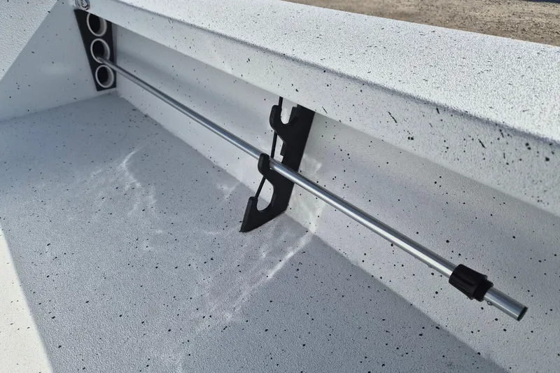 Slide: The Image of Interior view of 2026 Xpress Skiff 185 boat, featuring rod holders and speckled finish. - 14
