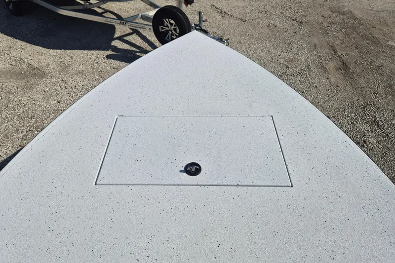 Slide: The Image of 2026 Xpress Skiff 185 boat deck with storage hatch, parked on a trailer. - 17