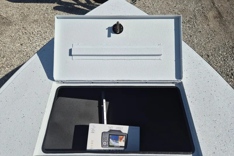 Slide: The Image of Open storage compartment on 2026 Xpress Skiff 185 boat, containing a GPS device. - 18