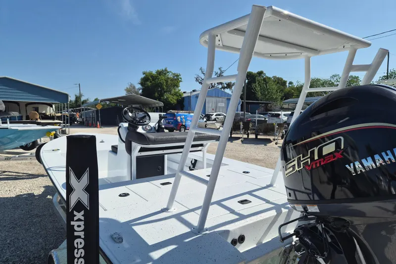 Slide: The Image of 2026 Xpress Skiff 185 boat with Yamaha engine, parked outdoors under clear sky. - 4