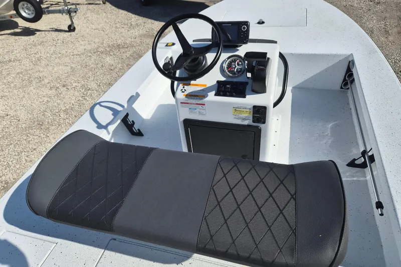 Slide: The Image of 2026 Xpress Skiff 185 boat interior with steering wheel and cushioned seat. - 9