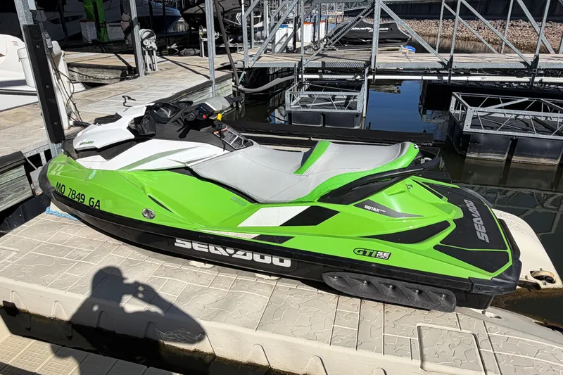 Slide: The Image of 2014 Sea-Doo GTI 130 jet ski in vibrant green, docked at a marina. - 10