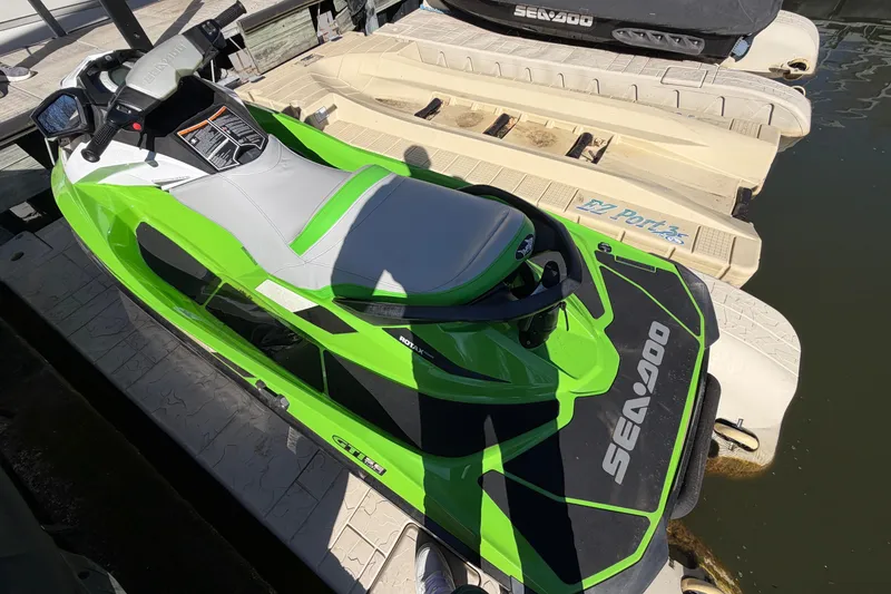 Slide: The Image of Green 2014 Sea-Doo GTI 130 jet ski docked on a floating platform. - 14