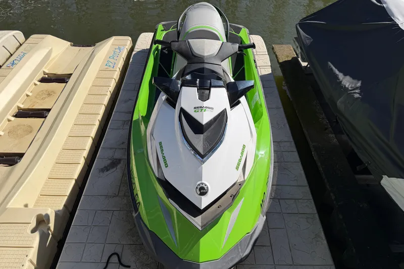 Slide: The Image of 2014 Sea-Doo GTI 130 jet ski in vibrant green, docked by the water. - 17