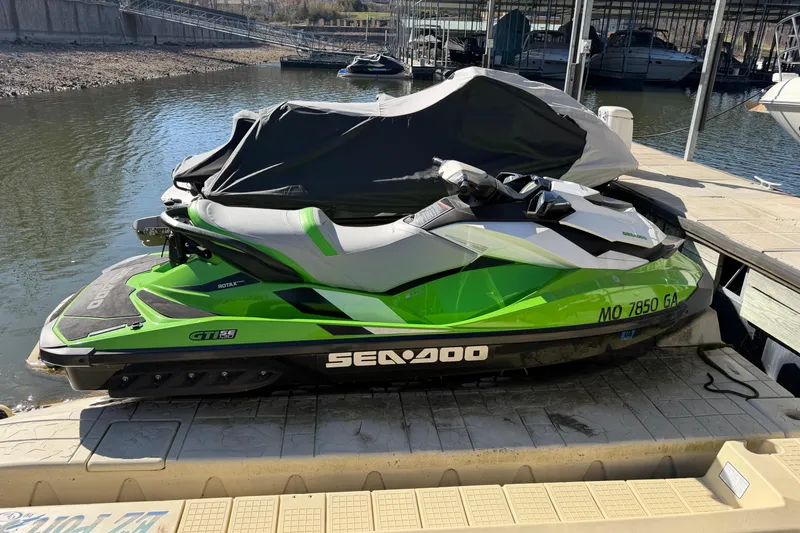 Slide: The Image of 2014 Sea-Doo GTI 130 jet ski in vibrant green, docked by the water. - 18