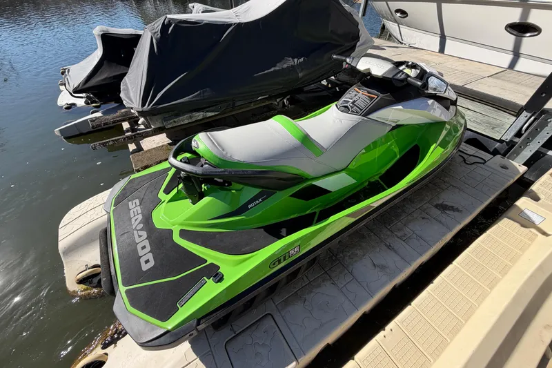 Slide: The Image of 2014 Sea-Doo GTI 130 jet ski in vibrant green, docked by the water. - 19