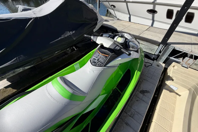Slide: The Image of 2014 Sea-Doo GTI 130 jet ski in vibrant green, docked near a marina. - 21