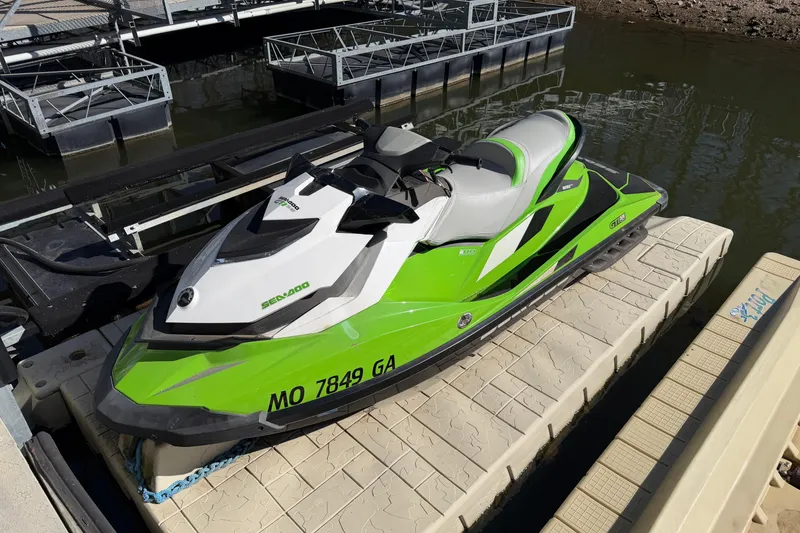 Slide: The Image of 2014 Sea-Doo GTI 130 jet ski in vibrant green, docked on a floating platform. - 7