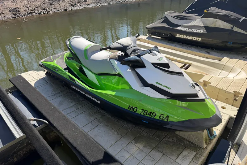 Slide: The Image of 2014 Sea-Doo GTI 130 jet ski in vibrant green, docked by the water. - 9
