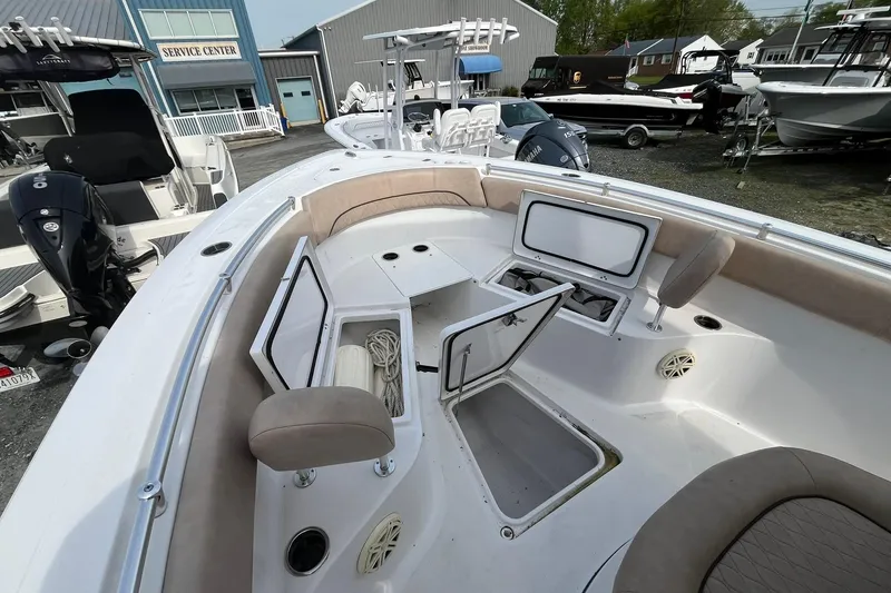Slide: The Image of 2020 Sportsman Open 252 Center Console boat with open storage compartments at a service center. - 5