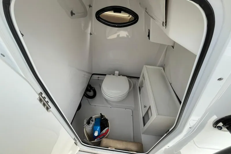 Slide: The Image of 2020 Sportsman Open 252 Center Console boat interior with toilet and storage. - 8