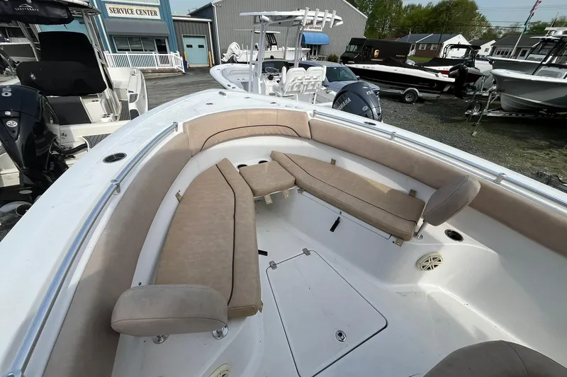 Slide: The Image of 2020 Sportsman Open 252 Center Console boat with beige seating in a service center. - 9