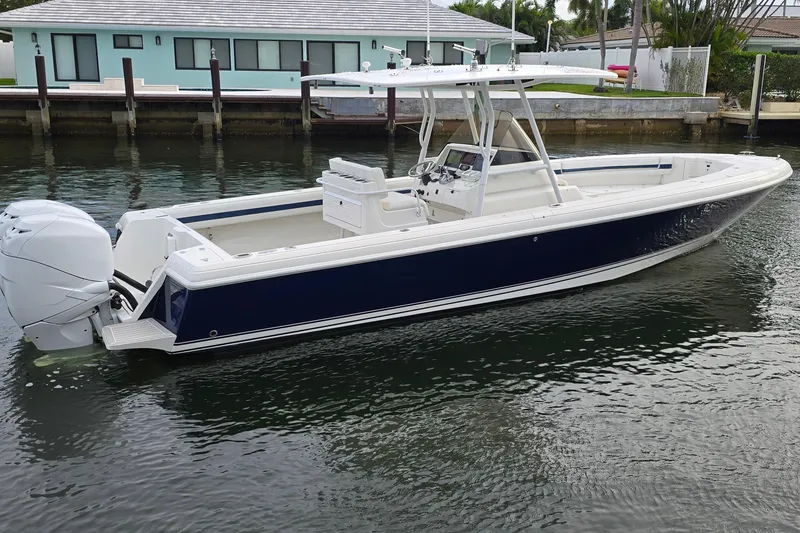 Slide: The Image of 2007 Intrepid 323 Open boat with dual engines, docked in a calm waterway. - 10
