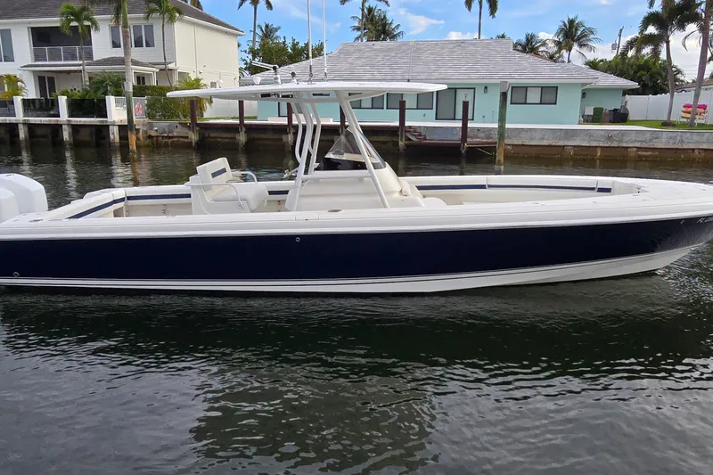 Slide: The Image of 2007 Intrepid 323 Open boat docked by waterfront homes, featuring sleek design and spacious deck. - 11