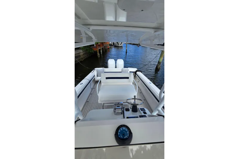 Slide: The Image of 2007 Intrepid 323 Open boat interior with steering wheel and seating, docked by the water. - 8