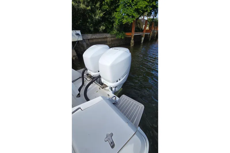 Slide: The Image of Twin outboard motors on a 2007 Intrepid 323 Open boat, docked by lush greenery. - 9