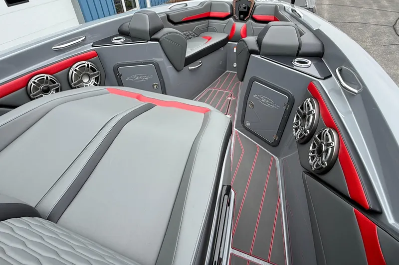 Slide: The Image of 2025 Sunsation 32 CCX boat interior with sleek gray and red seating and modern audio system. - 12