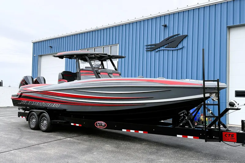 Slide: The Image of 2025 Sunsation 32 CCX boat on trailer, parked outside blue building. - 4