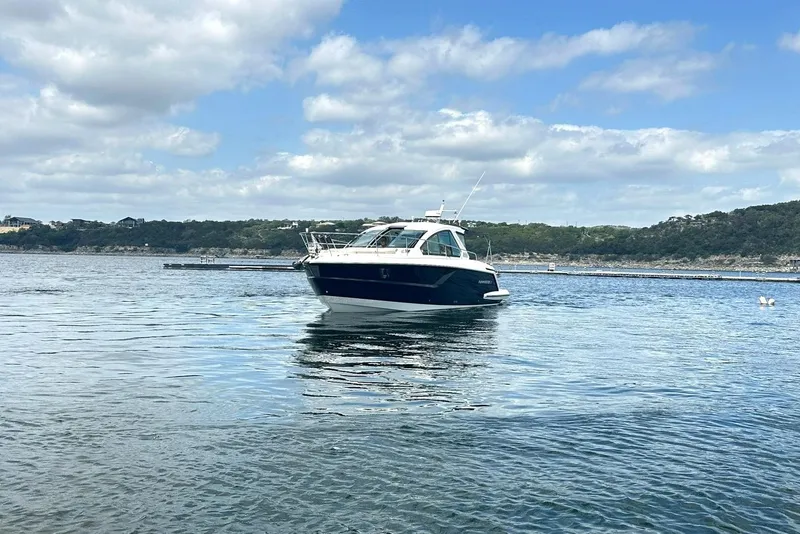Slide: The Image of 2017 Monterey 360 Sport Coupe on calm water under a partly cloudy sky. - 11